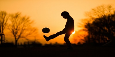 夕日とサッカー少年